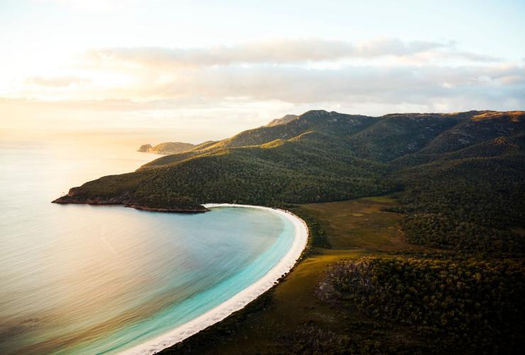 Vue aérienne sur l'arche de sable blanc et l'océan à Wineglass Bay, Freycinet National Park, Tasmanie © Lauren Bath