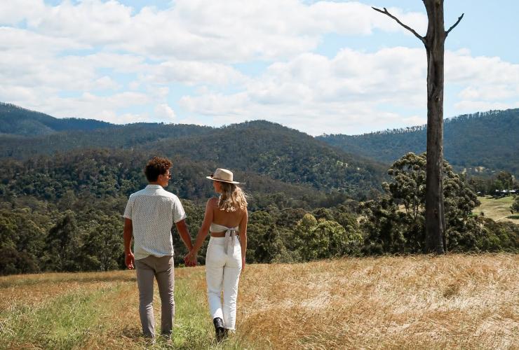 Un couple marchant sur une colline verte entourée de bush, Currajong Retreat, Nouvelle-Galles du Sud © Amy Fraser