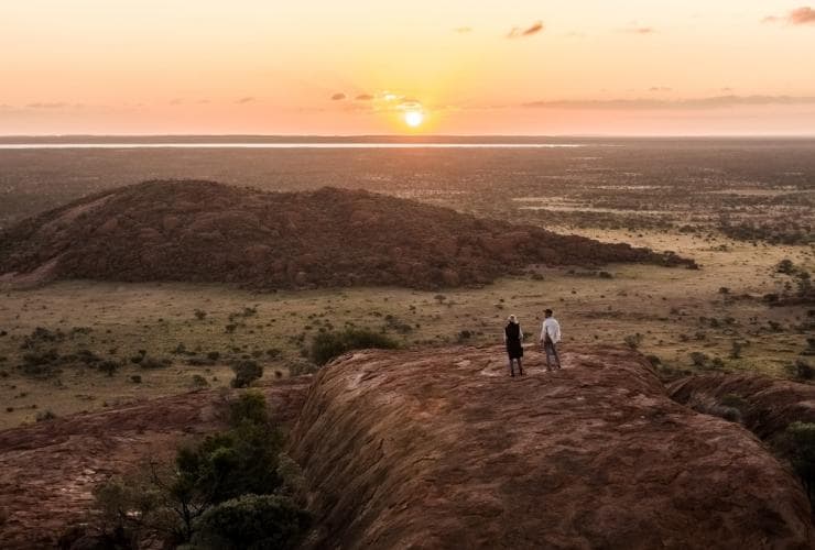 Deux personnes admirant la vue sur l'arrière-pays au coucher du soleil à Wooleen Station, Golden Outback, Australie Occidentale © Tourism Australia