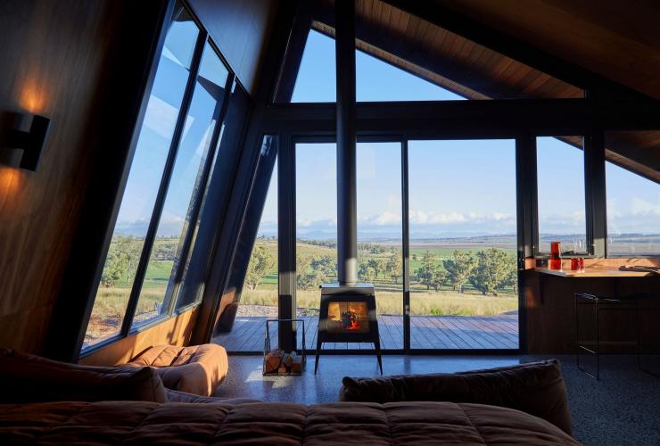 Intérieur d'une tiny house avec une cheminée surplombant la campagne, Gilay Estate, Quirindi, Nouvelle-Galles du Sud © Gilay Estate