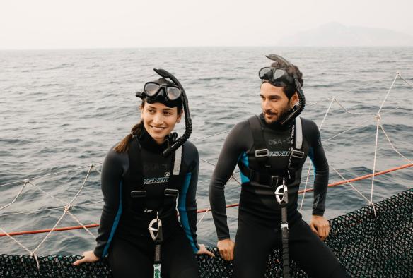 Deux personnes assises à bord d’un bateau vêtues de combinaisons de plongée et portant un masque et un tuba, Dolphin Swim Australia, Port Stephens, Nouvelle-Galles du Sud © Destination NSW