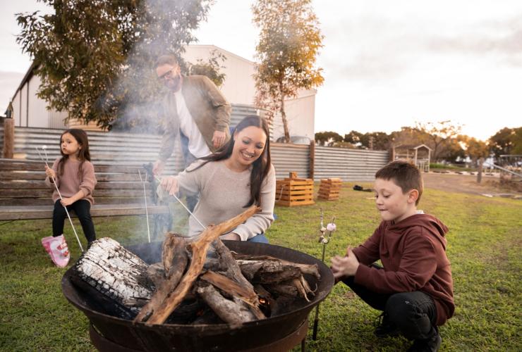 Keluarga memanggang marshmallow di atas api unggun di Redwing Farm, Yorke Peninsula, South Australia © Tourism Australia