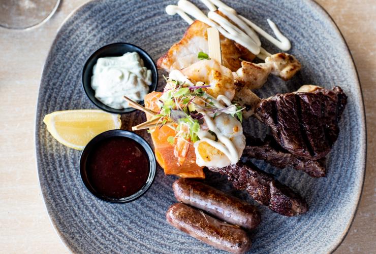 Hidangan aneka cicipan dari bahan-bahan khas Australia termasuk chipolata buaya di Dundee’s Waterfront Restaurant, Cairns, Queensland © Alexandra Gow