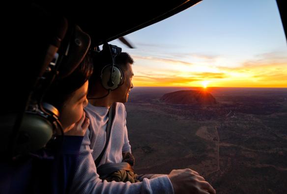 Pasangan menikmati pemandangan Uluru saat matahari terbit dari helikopter, Uluru-Kata Tjuta National Park, Northern Territory © Tourism NT/Shaana McNaught