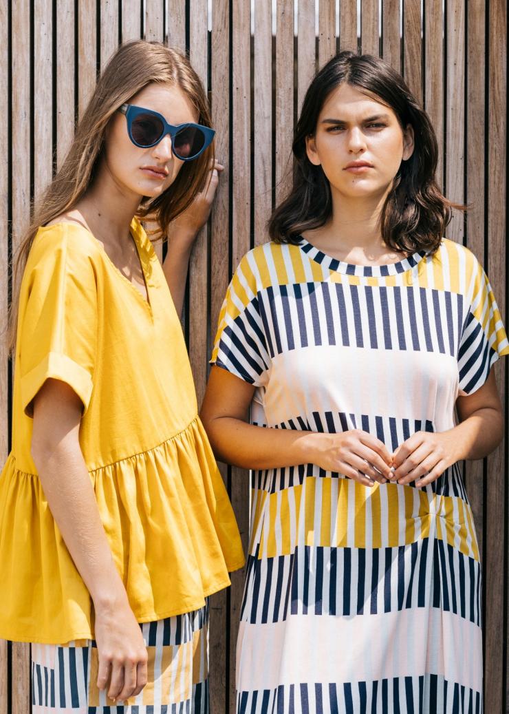 Dua model berpose mengenakan pakaian kuning yang mencolok, Busana Elk, Little Collins Street, Melbourne, Victoria © ELK