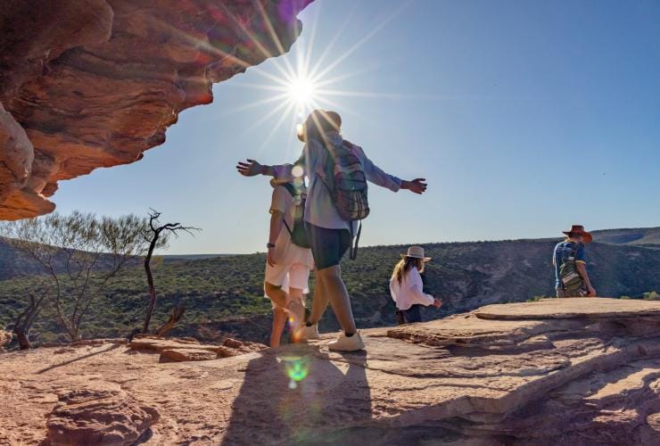 Para penjelajah alam berjalan di sepanjang bebatuan terjal dan padang semak di Kalbarri National Park, Western Australia © Tourism Western Australia