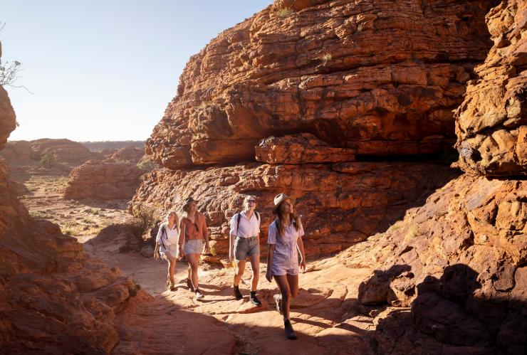 Sekelompok orang mengagumi pemandangan saat mendaki melalui lanskap bebatuan merah, Kings Canyon Rim Walk, Kings Canyon, Northern Territory © Tourism NT/Tourism Australia