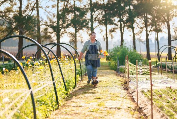Una donna cammina in un giardino fiorito, Scenic Rim Farm Shop and Cafe, Kalbar, Queensland © Tourism Australia