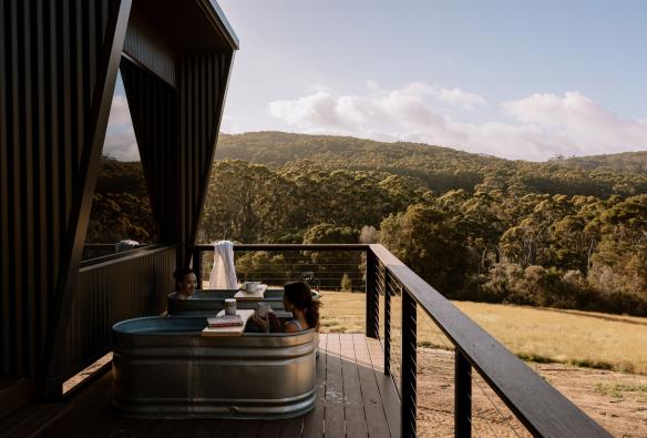 Coppia che fa il bagno in vasche all’aperto presso le baite Heyscapes, Denmark, Western Australia © Joia Ellery &amp; Adan Kenna