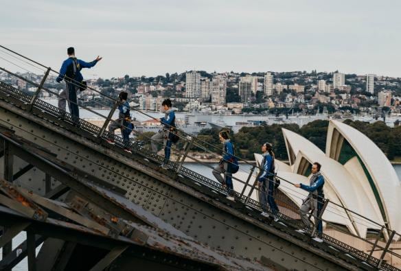 Un gruppo di persone che scala un ponte con arcate in acciaio durante il Burrawa Climb sul Sydney Harbour Bridge, Sydney, New South Wales © Destination NSW