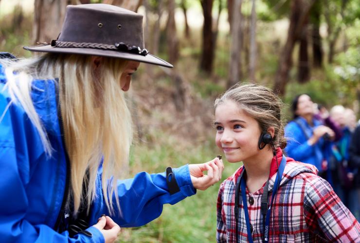 Bambino che indossa delle cuffie con una guida di Wildlife Wonders, Great Ocean Road, Victoria © Tourism Australia/Wildlife Wonders