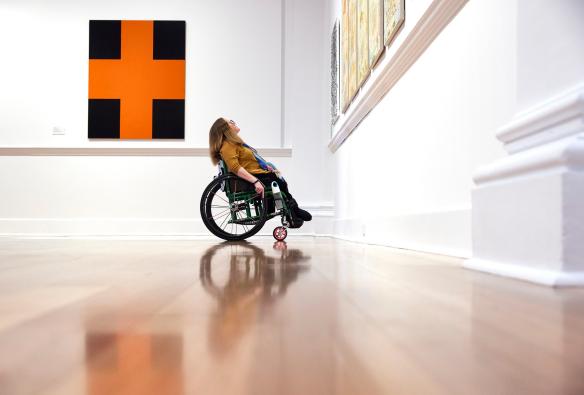 Donna su una sedia a rotelle che ammira l'arte della Geelong Gallery, Geelong, Victoria © Tourism Australia
