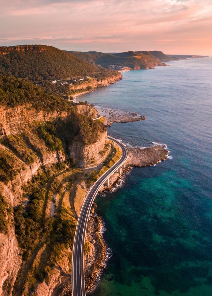Vista dall'alto di auto che percorrono un ponte affacciato sull'oceano sul Sea Cliff Bridge, Clifton, New South Wales © Destination NSW 