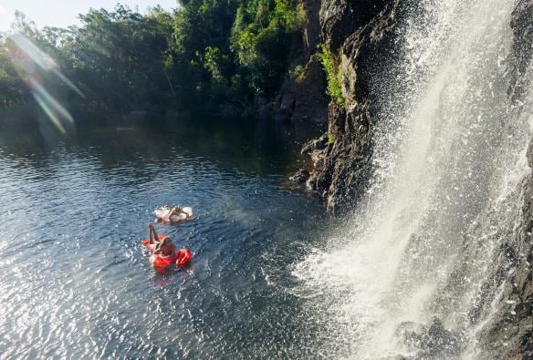 Due persone in acqua su materassini gonfiabili ai piedi di una cascata alle Wangi Falls, Litchfield National Park, Northern Territory © Tourism NT/Matt Cherubino