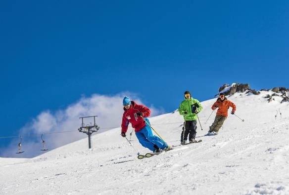 Tre persone che sciano su una montagna innevata a Thredbo, Snowy Mountains, New South Wales © Destination New South Wales
