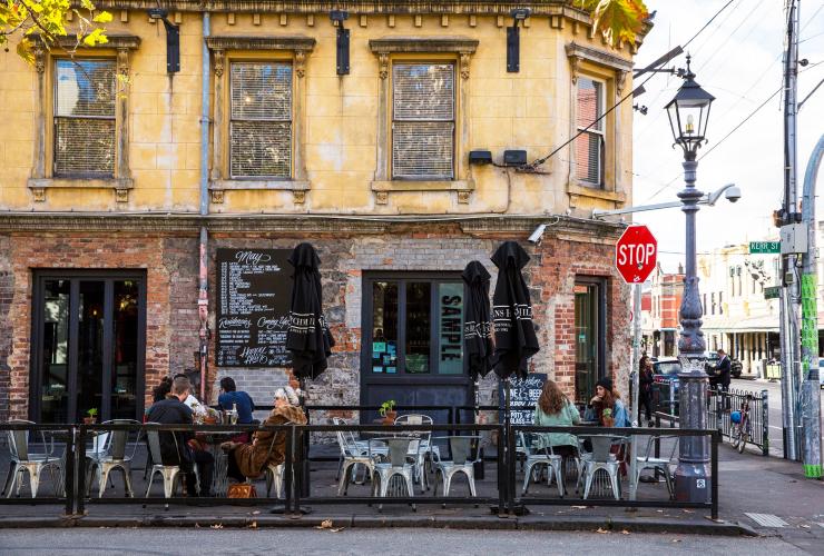 Persone sedute ai tavoli di un bar lungo Brunswick Street a Fitzroy, Melbourne, Victoria © Visit Victoria