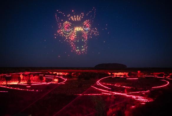 Un gruppo di droni che creano l'immagine di un cane nel cielo notturno sopra a un campo pieno di luci durante lo spettacolo Wintjiri Wiru, Uluru-Kata Tjuta National Park, Northern Territory © Getty Images for Voyages Indigenous Tourism Australia