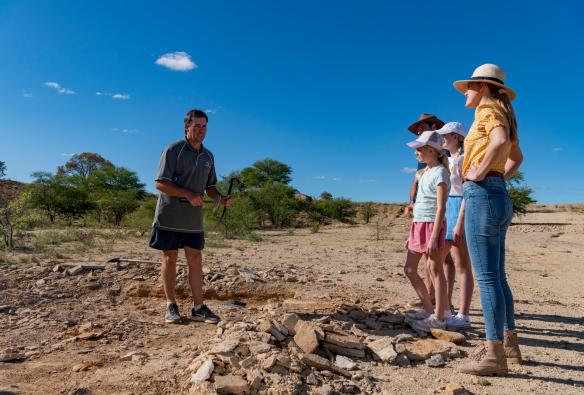 Una guida indica i fossili nella terra al Kronosaurus Korner, Richmond, Queensland © Tourism and Events Queensland