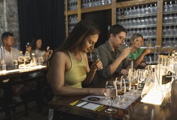 Gruppo di persone sedute che annusano diversi distillati durante la Bundaberg Rum Experience, Bundaberg, Queensland © Tourism and Events Queensland