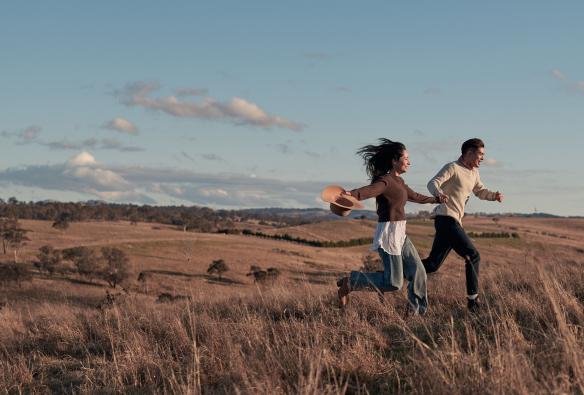 Una coppia che corre tra i pascoli al Wilga Station, Evans Plains, New South Wales © Destination NSW