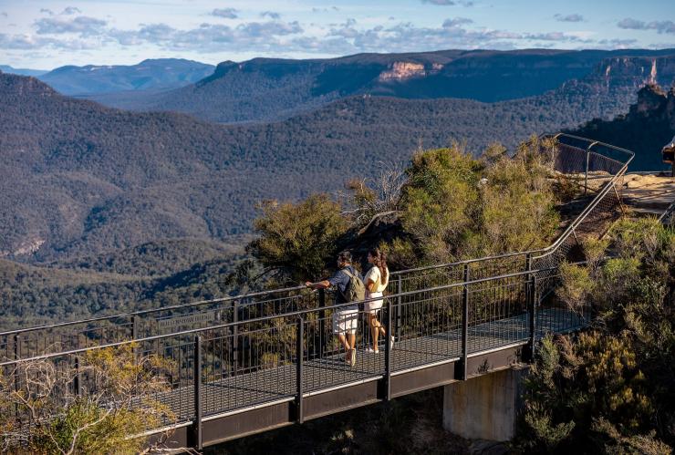 Due persone in piedi su una passerella che si affaccia su una valle sconfinata, Grand Cliff Top Walk, Blue Mountains, New South Wales © Tourism Australia