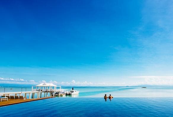 Coppia che osserva l'oceano dalla piscina a sfioro dell'Orpheus Island Lodge, Orpheus Island, Queensland © Orpheus Island