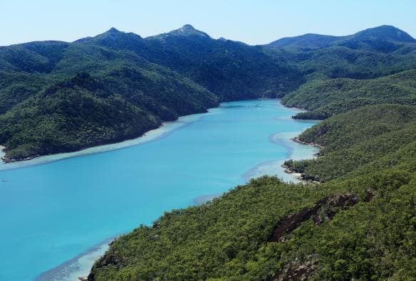 Vista aerea delle limpide acque blu di Nara Inlet circondate dal verde di Hamilton Island vicino al qualia, Queensland © qualia