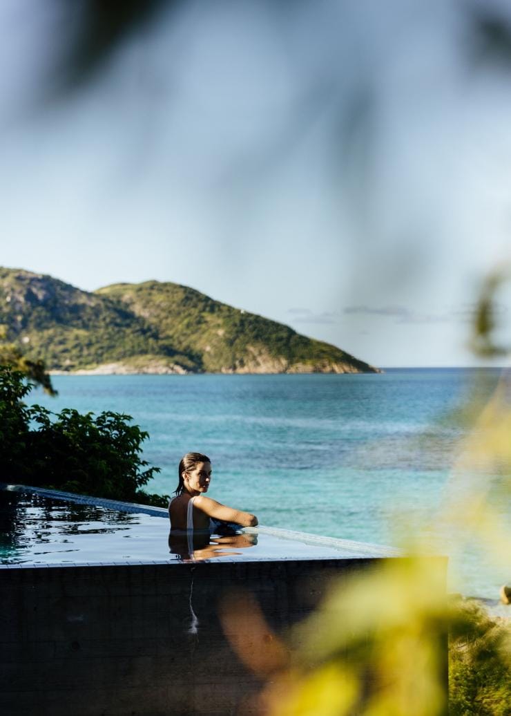 Una persona nuota in una piscina con vista sull'oceano, Lizard Island Resort, Lizard Island, Queensland © Tourism Australia