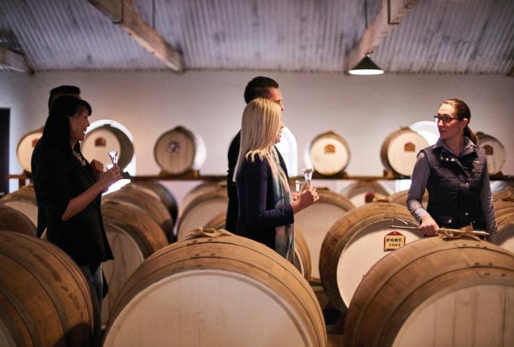 Un gruppo di persone che passeggia in una cantina piena di botti, Seppeltsfield, Barossa Valley, South Australia © South Australian Tourism Commission