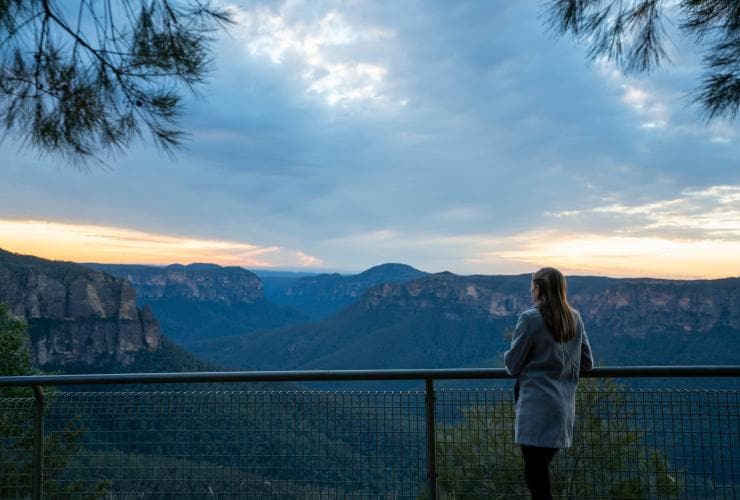 Una donna che ammira un panorama di montagne tinte di blu al Govetts Leap Lookout, Blue Mountains, New South Wales © Tourism Australia 