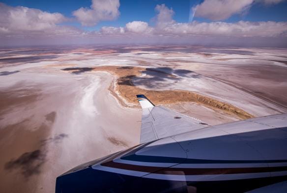 Vista dal finestrino di un volo panoramico sulle acque rosa e bianche di Kati Thanda-Lake Eyre, outback del South Australia © Sky Dance