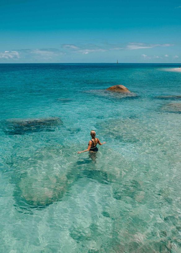 Una persona che nuota nelle acque cristalline dell’oceano, Fitzroy Island, Tropical North Queensland, Queensland © Tourism Australia