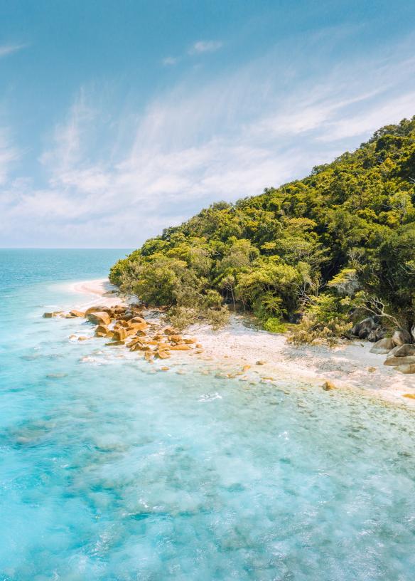 Un’isola ricoperta di alberi con una costa di sabbia bianca accanto alle acque cristalline dell’oceano, Fitzroy Island, Tropical North Queensland, Queensland © Tourism and Events Queensland