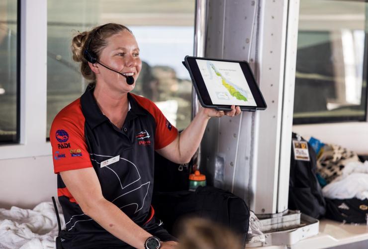 Una guida di Passions of Paradise con un tablet durante una conversazione didattica, Grande Barriera Corallina, Queensland © Tourism Australia