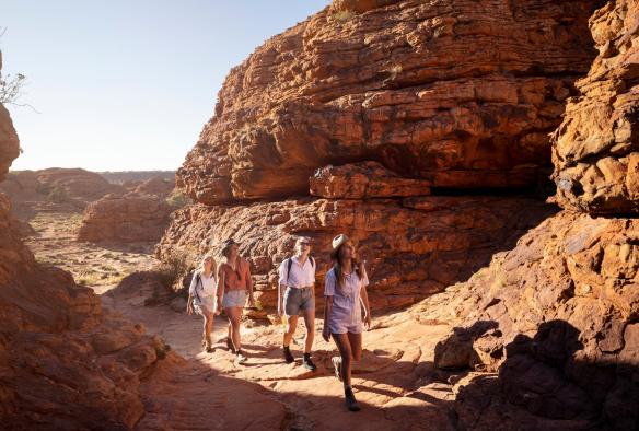 Un gruppo di persone ammira il panorama durante un’escursione nel paesaggio roccioso rosso, Kings Canyon Rim Walk, Kings Canyon, Northern Territory © Tourism NT/Tourism Australia