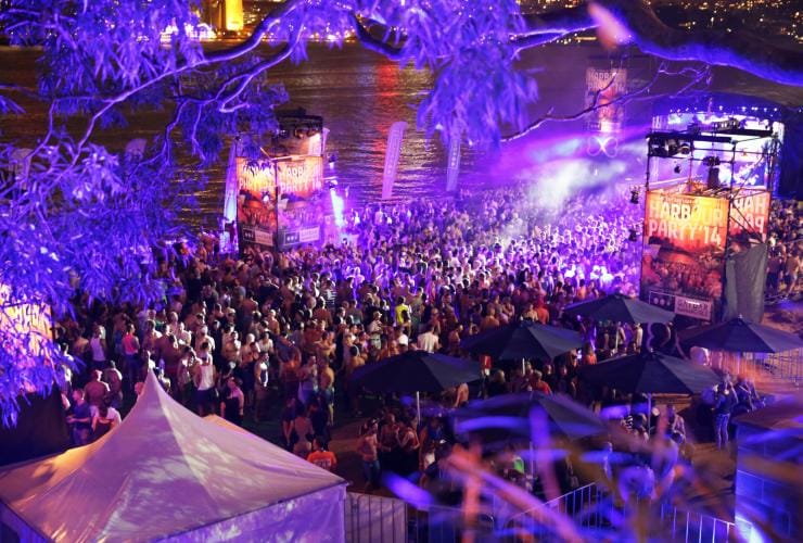 ニュー・サウス・ウェールズ州、シドニー、シドニー・マルディグラ。夜のハーバーでパーティーに興じる群衆の空撮 © Sydney Gay and Lesbian Mardi Gras