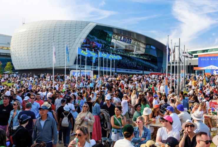 ビクトリア州、メルボルン、全豪オープンテニス。晴れた日のスタジアム外でファンファーレに歓喜する群衆 © Greg Elms/ Visit Victoria