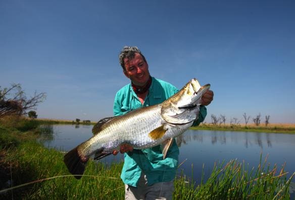 西オーストラリア州、キンバリー、ヘリスピリット、穏やかな水場の横で大きな魚を持つ男性 © HeliSpirit