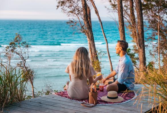 クイーンズランド州、ヌーサ、リトル・コーブ・ビーチを見下ろしながら夕方のピクニック © Tourism and Events Queensland
