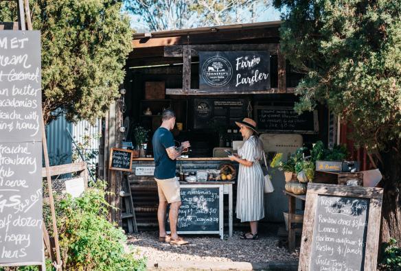 クイーンズランド州、ケリー、トマラップス酪農場、マーケットの屋台でチーズを試食するカップル © Tourism and Events Queensland