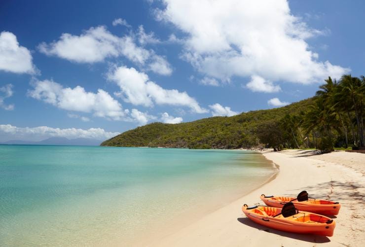 クイーンズランド州、オーフィアス島、オーフィアス・アイランド・ロッジの海、砂浜にある2艇のオレンジ色のカヌー © Tourism Australia