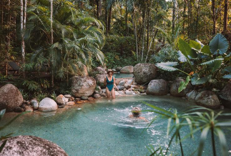 クイーンズランド州、デインツリー・レインフォレスト、シルキー・オークス・ロッジの熱帯雨林に囲まれた透明な青いプールで泳ぐカップル © Tourism and Events Queensland