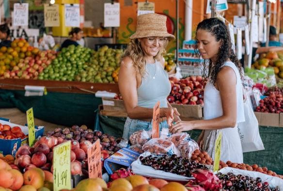 Hai người bạn đang lựa chọn trái cây tại một cửa hàng tại khu chợ Rusty’s Market, Thành phố Cairns, Tiểu bang Queensland © Tourism and Events Queensland/ Tourism Tropical North Queensland