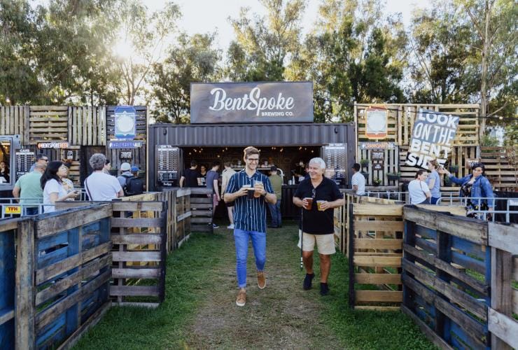 Hai người đàn ông mang theo bia tại khu BentSpoke Beer Garden trong Lễ hội Enlighten, Thành phố Canberra, Lãnh thổ Thủ đô Úc © 5 Foot Photography, Davey Barber for VisitCanberra