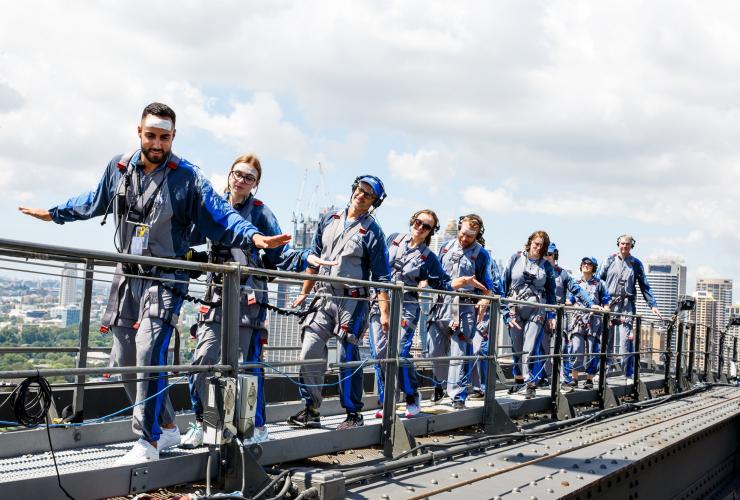 People walking on top of a bridge with their arms outstretched during the Burrawa Climb on the Sydney Harbour Bridge, Sydney, New South Wales © BridgeClimb