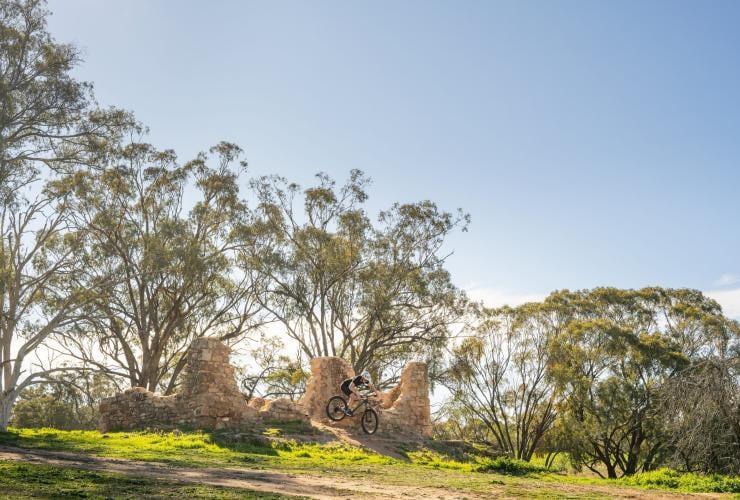 A person riding a mountain bike in the air over a jump through a pile of bricks at Melrose, Flinders Ranges and Outback, South Australia © Heidi Who Photos