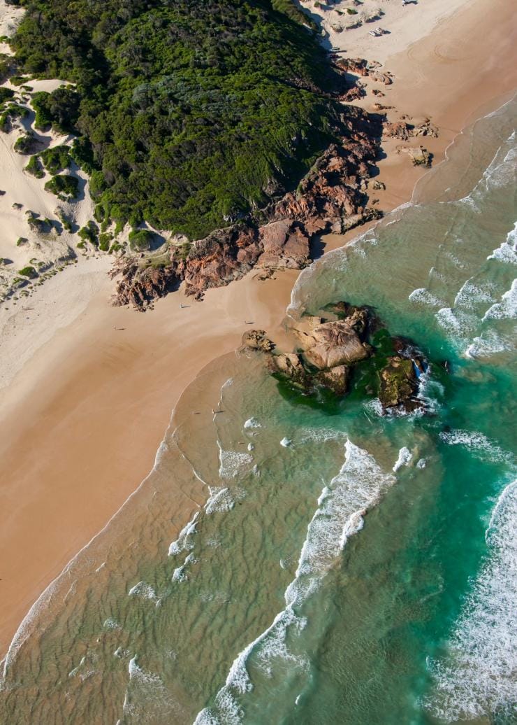 Aerial view of a green headland separating two beaches at Samurai Point, Port Stephens, New South Wales © Destination NSW 