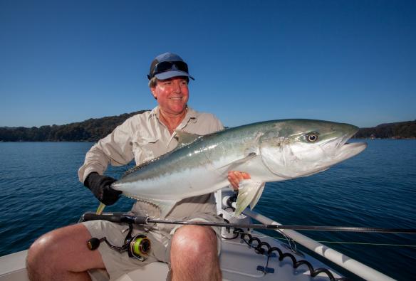 Một ngư dân ngồi trên thuyền đang cầm con cá Cam Úc lớn, Sydney Flyfishing Tours, Thành phố Sydney, Tiểu bang New South Wales © Sydney Flyfishing Tours