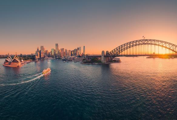 Sydney Harbour with the Opera House and Harbour Bridge lit up at sunset in Sydney, New South Wales © Tourism Australia