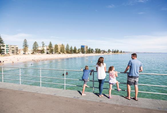 Một gia đình gồm bố mẹ và hai con đang đứng trên cầu tàu ngắm biển, Glenelg, Thành phố Adelaide, Tiểu bang Nam Úc © South Australian Tourism Commission